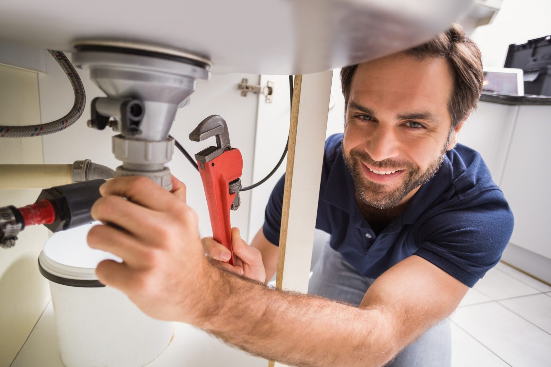 Plumber fixing under the sink