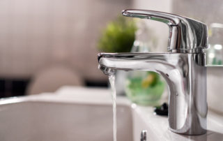 Cold water flowing from faucet in clean bathroom